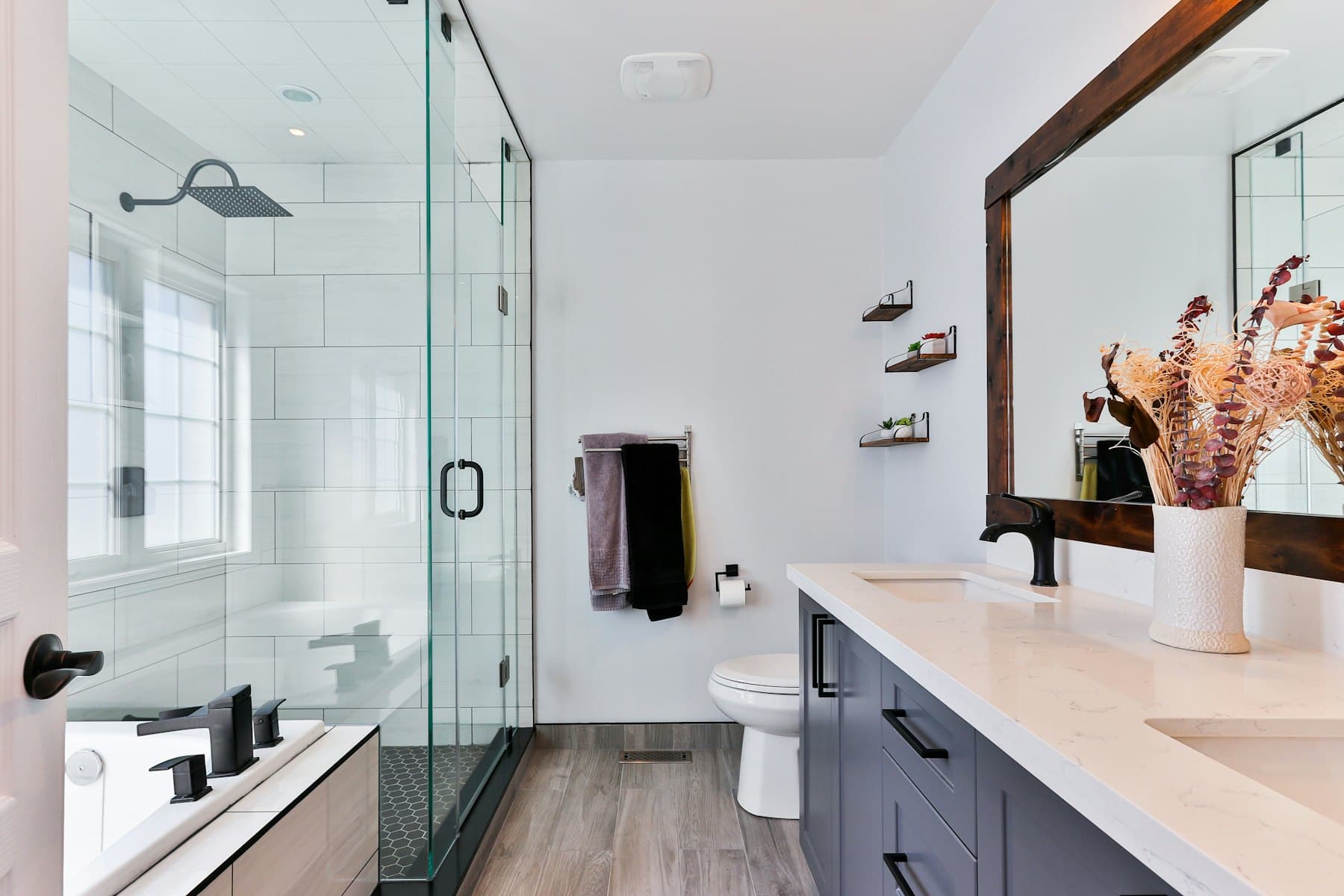 A finished bathroom with a glass shower enclosure and vanity unit