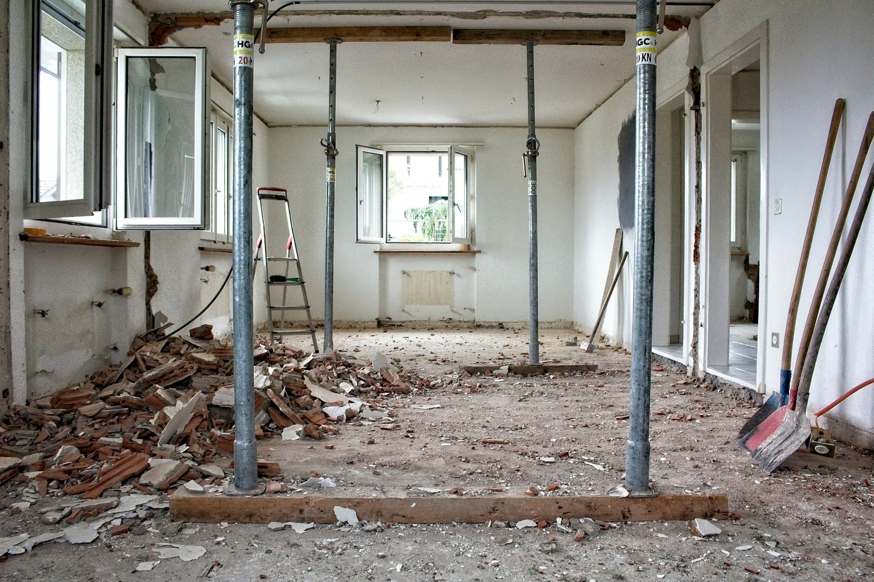 A room stripped back during structural refurbishment, with temporary steel props